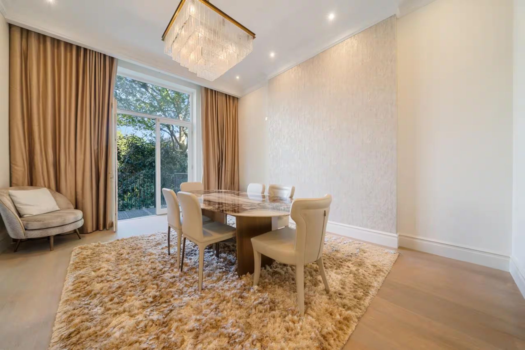 Dining room under a crystal chandelier, garden doors beyond