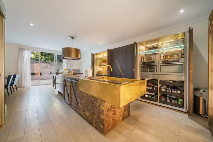Kitchen with marble and brass island and wine display wall
